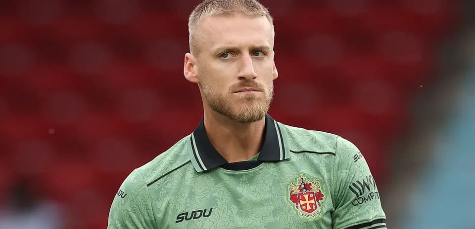Goalkeeper wearing green kit on the pitch