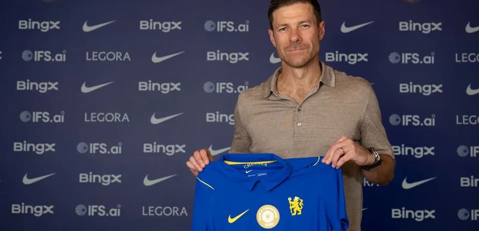 New coach holding Chelsea jersey at press event