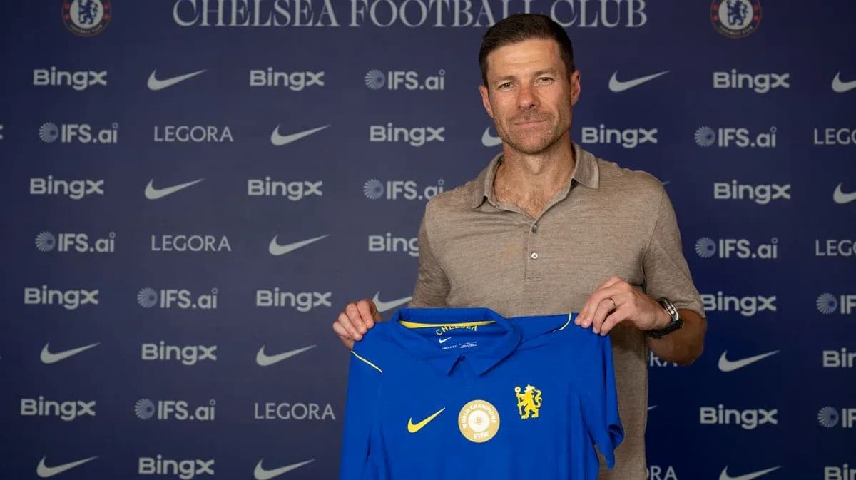 New coach holding Chelsea jersey at press event