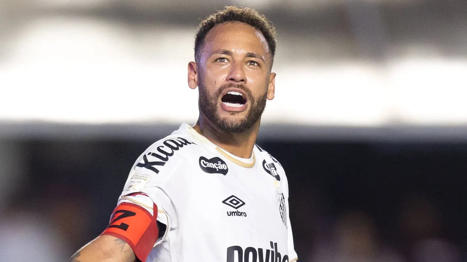 Player shouting while wearing team jersey and captain's armband