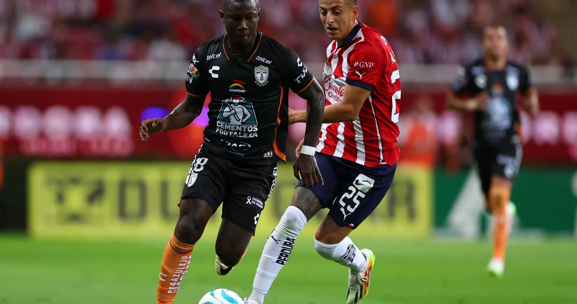 CF Pachuca player dribbling past Guadalajara Chivas opponent