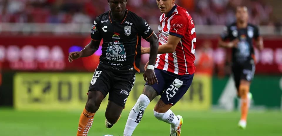 CF Pachuca player dribbling past Guadalajara Chivas opponent