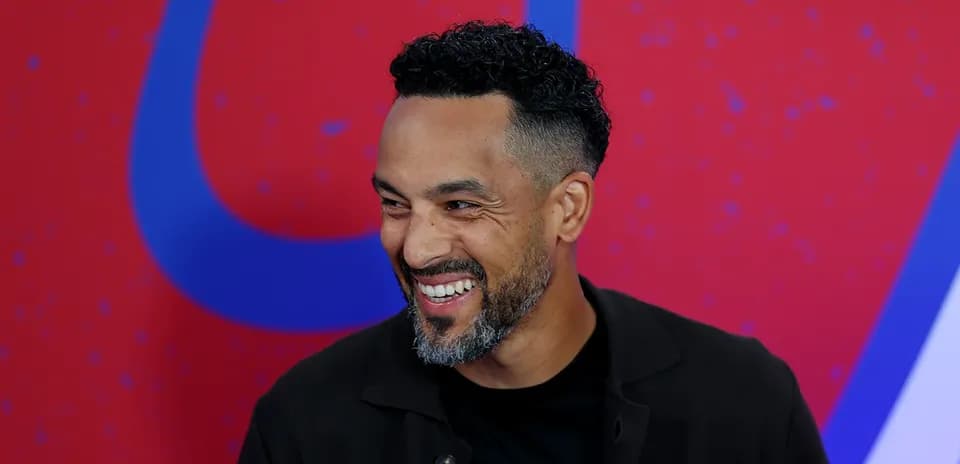 Man smiling during an interview with red background
