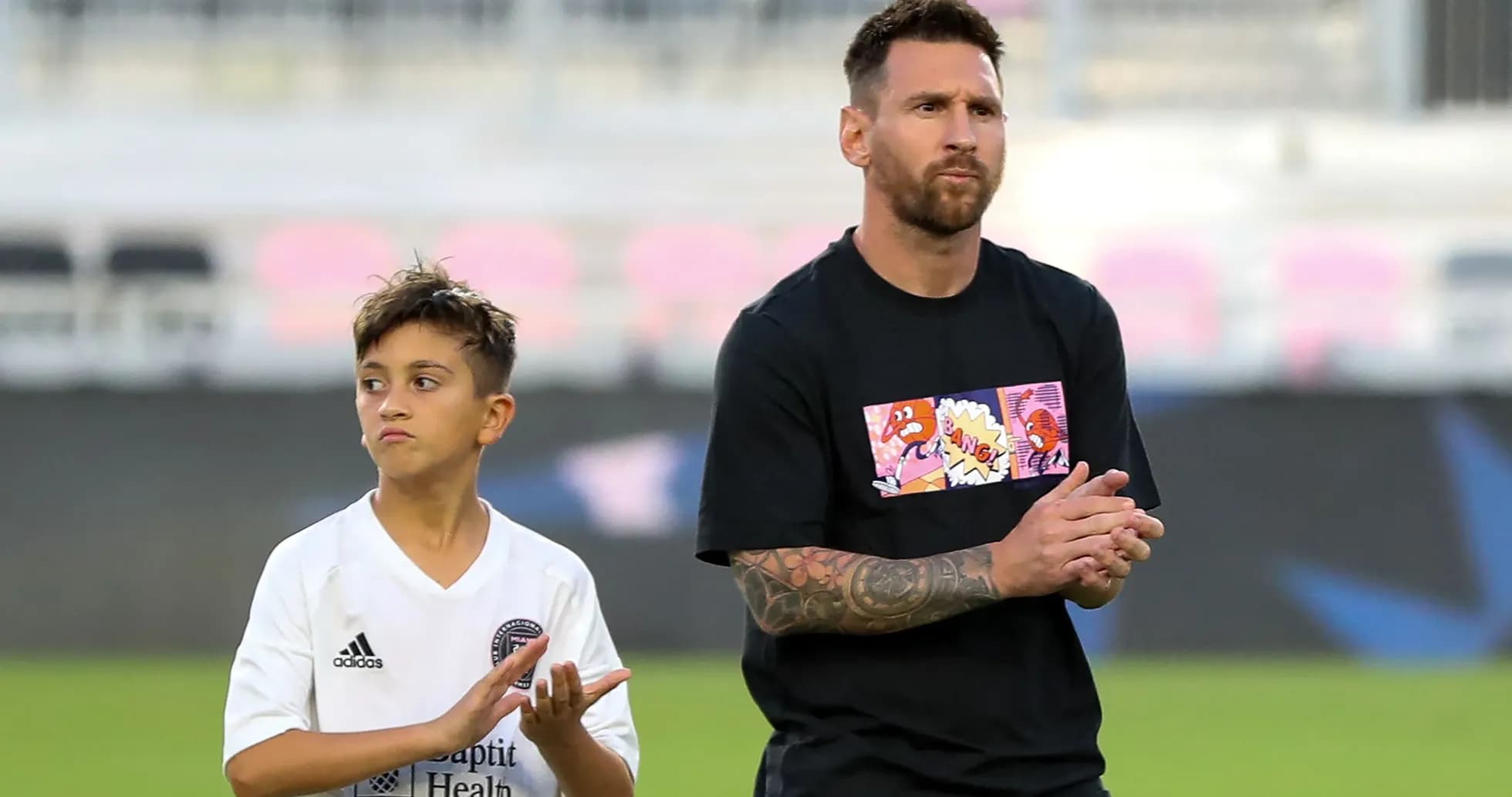 Lionel Messi and child clapping on the field