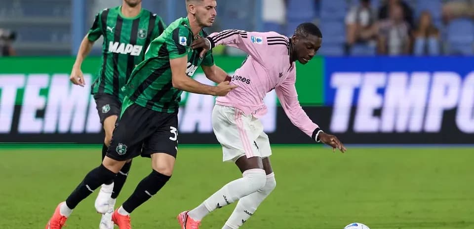 Sassuolo player challenges Juventus player for the ball