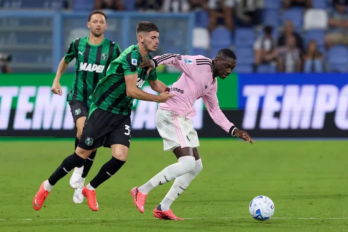 Sassuolo player challenges Juventus player for the ball