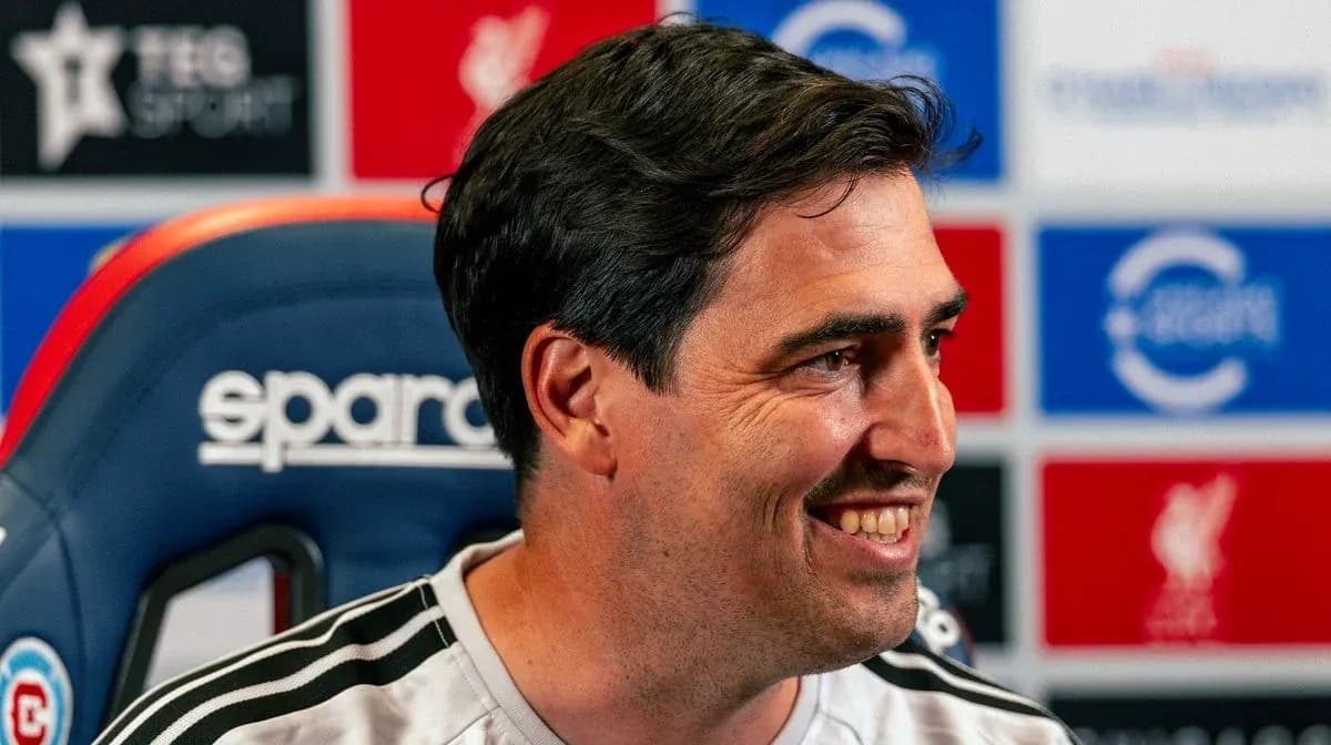 Manager smiling during press conference at podium