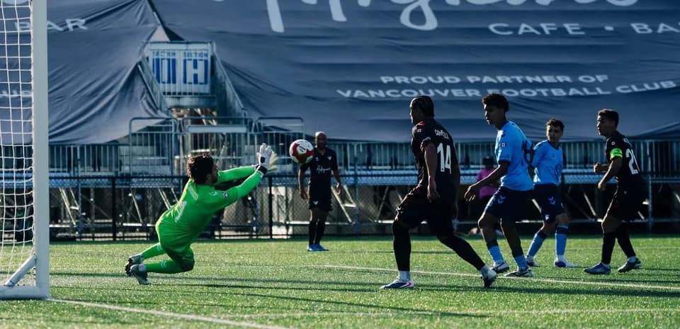 Goalkeeper attempting to save a shot on goal Goalkeeper attempting to save a shot on goal
