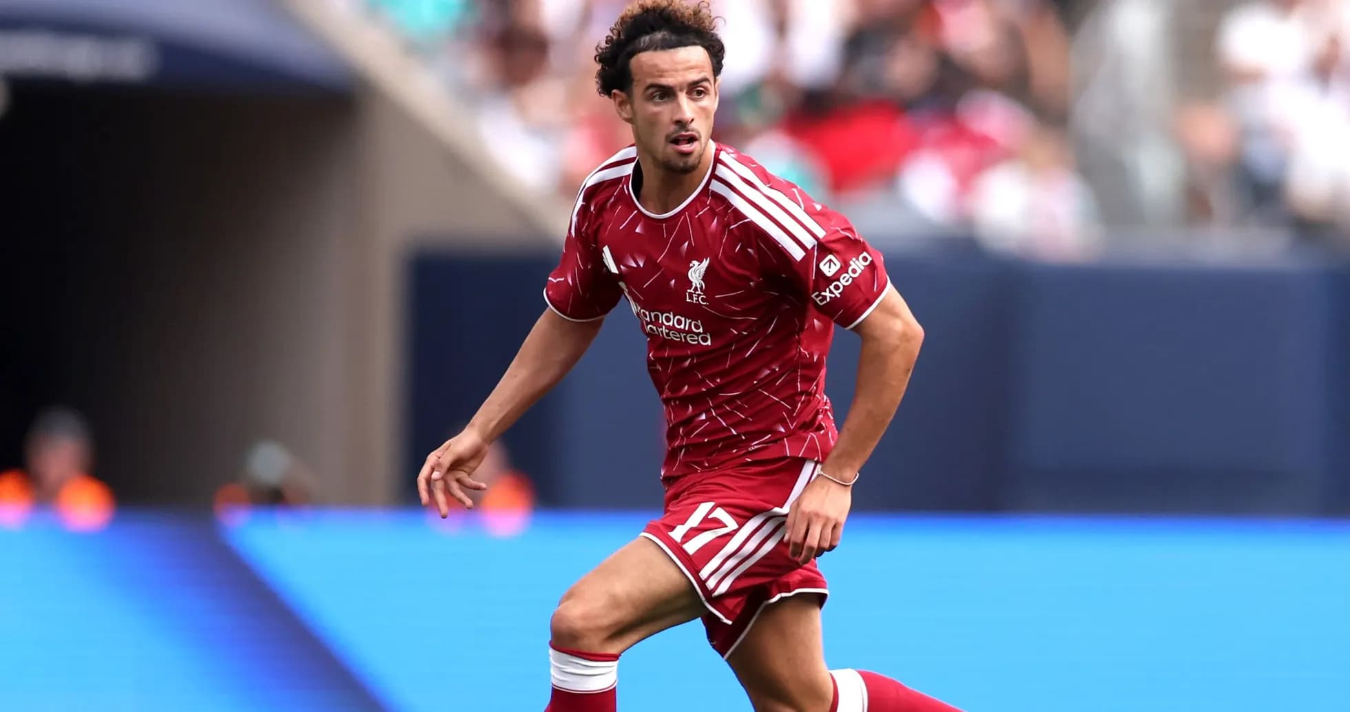 Player in Liverpool kit running on the field Player in Liverpool kit running on the field
