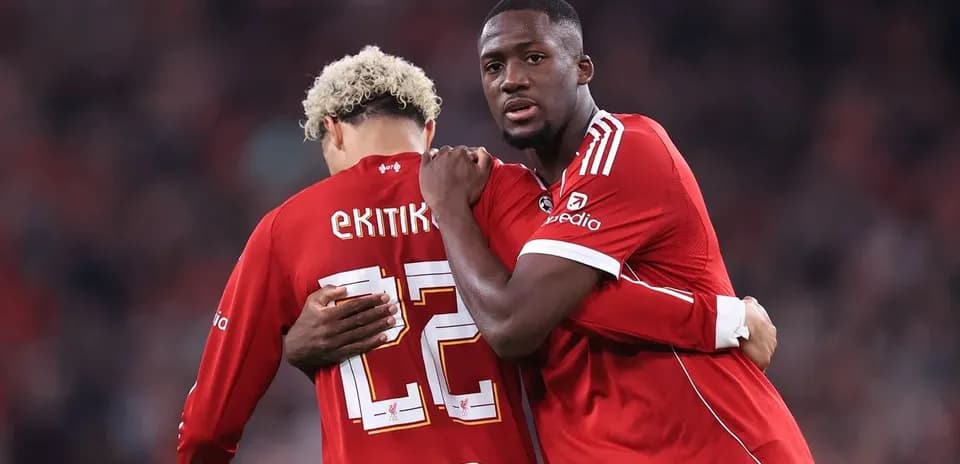 Two players in red jerseys embracing on field Two players in red jerseys embracing on field