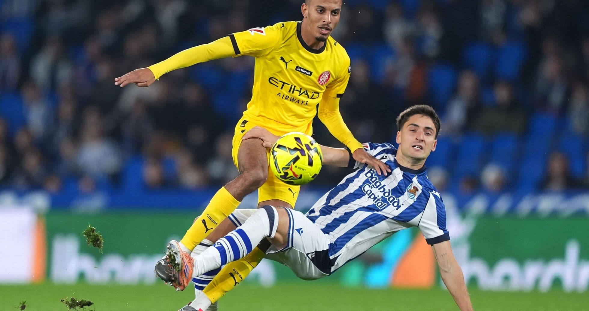 Player tackling during Girona vs Real Sociedad match Player tackling during Girona vs Real Sociedad match