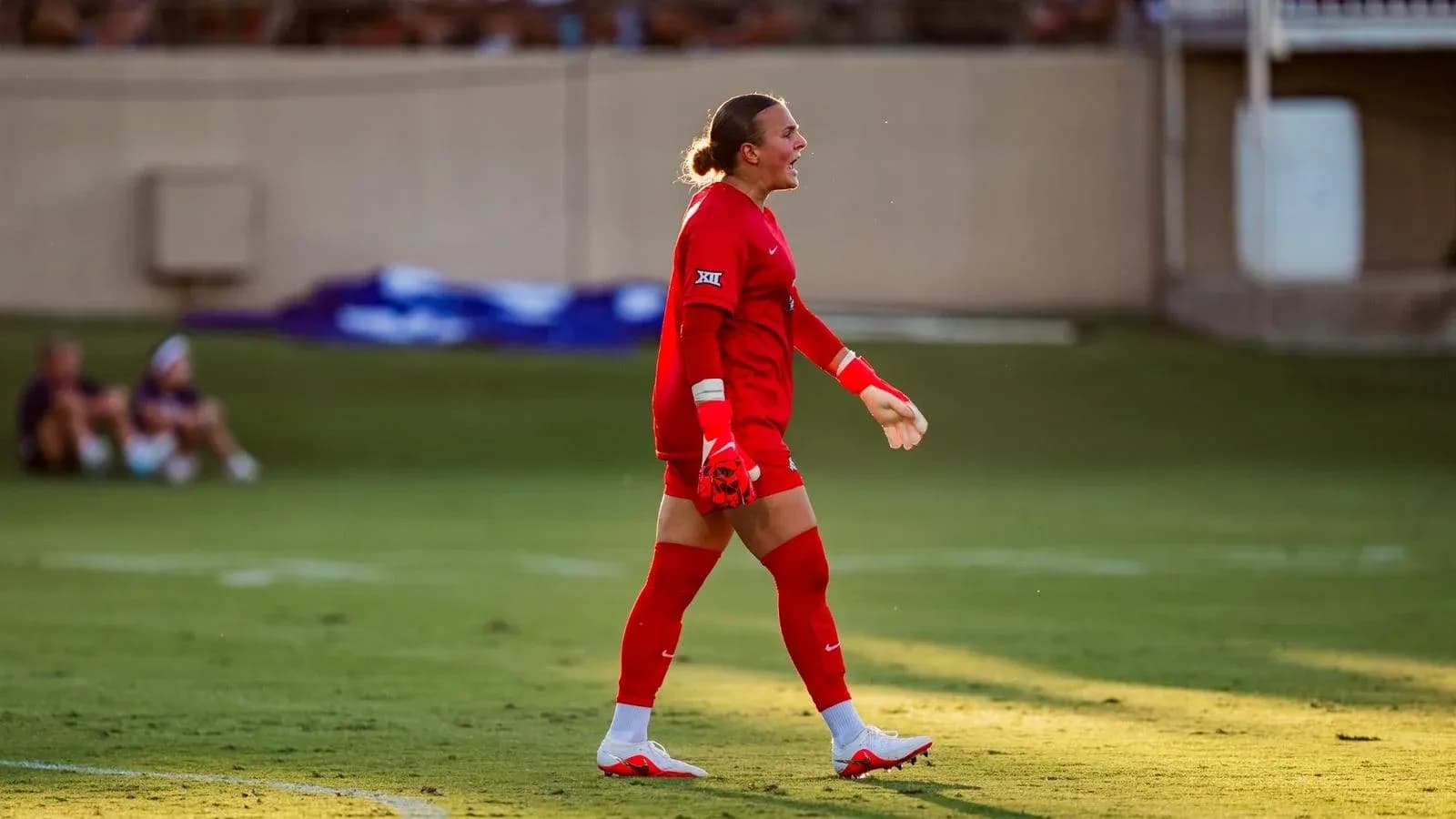 Goalkeeper in red uniform celebrating on the field Goalkeeper in red uniform celebrating on the field