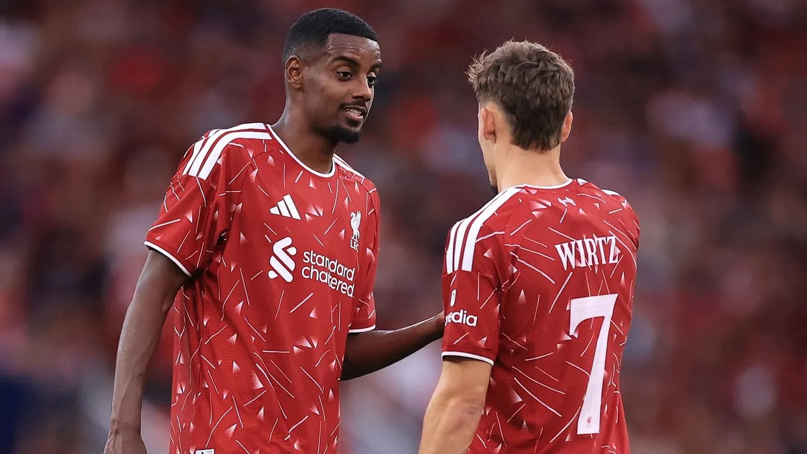 Two Liverpool players discussing on the pitch Two Liverpool players discussing on the pitch