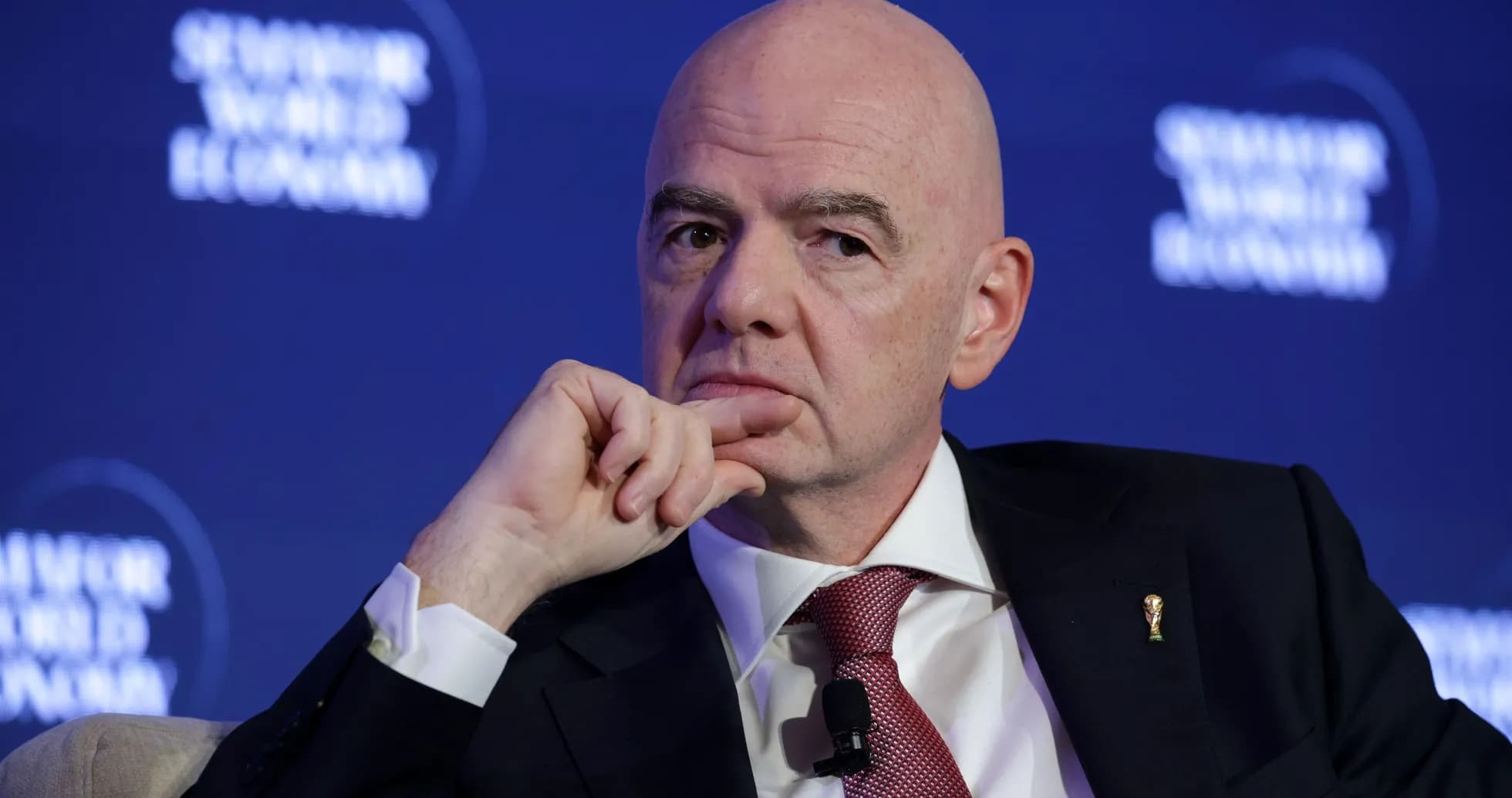 Man in suit during a conference, hand on chin Man in suit during a conference, hand on chin