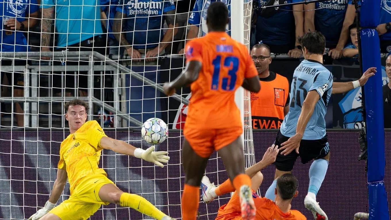 Goalkeeper attempting to save during UEFA match Goalkeeper attempting to save during UEFA match