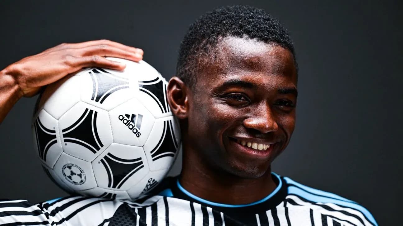 Player holding a soccer ball on his shoulder Player holding a soccer ball on his shoulder