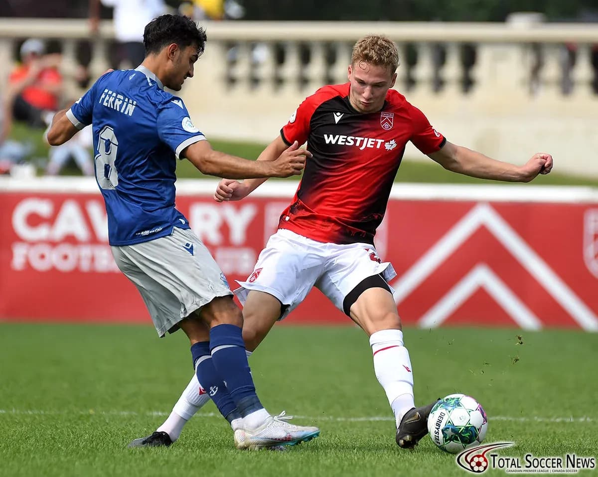 Cavalry FC player tackling HFX Wanderers player Cavalry FC player tackling HFX Wanderers player