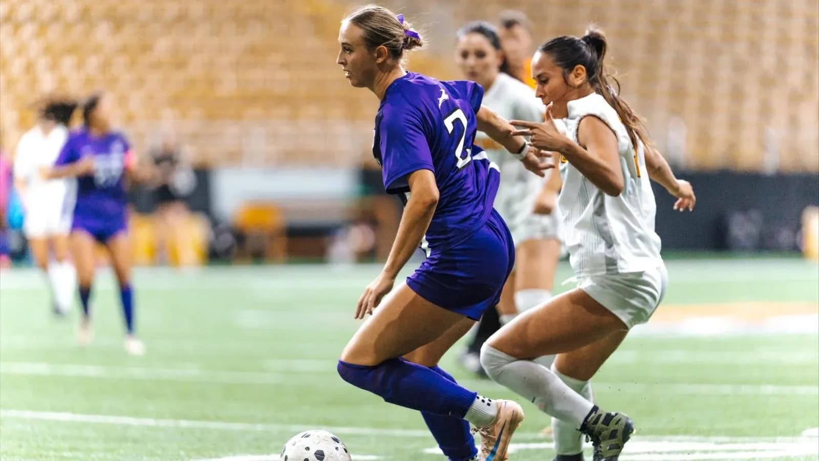 Two soccer players competing for the ball Two soccer players competing for the ball