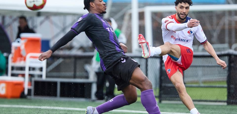 Vancouver FC player kicking ball against Supra du Quebec Vancouver FC player kicking ball against Supra du Quebec