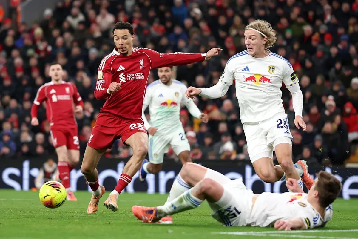 Liverpool player evading Leeds defenders during match Liverpool player evading Leeds defenders during match