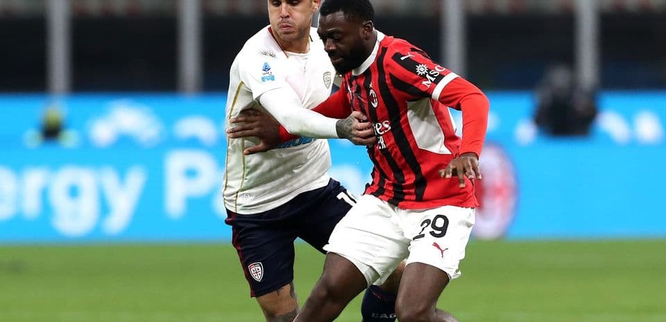 AC Milan player challenging Cagliari opponent AC Milan player challenging Cagliari opponent