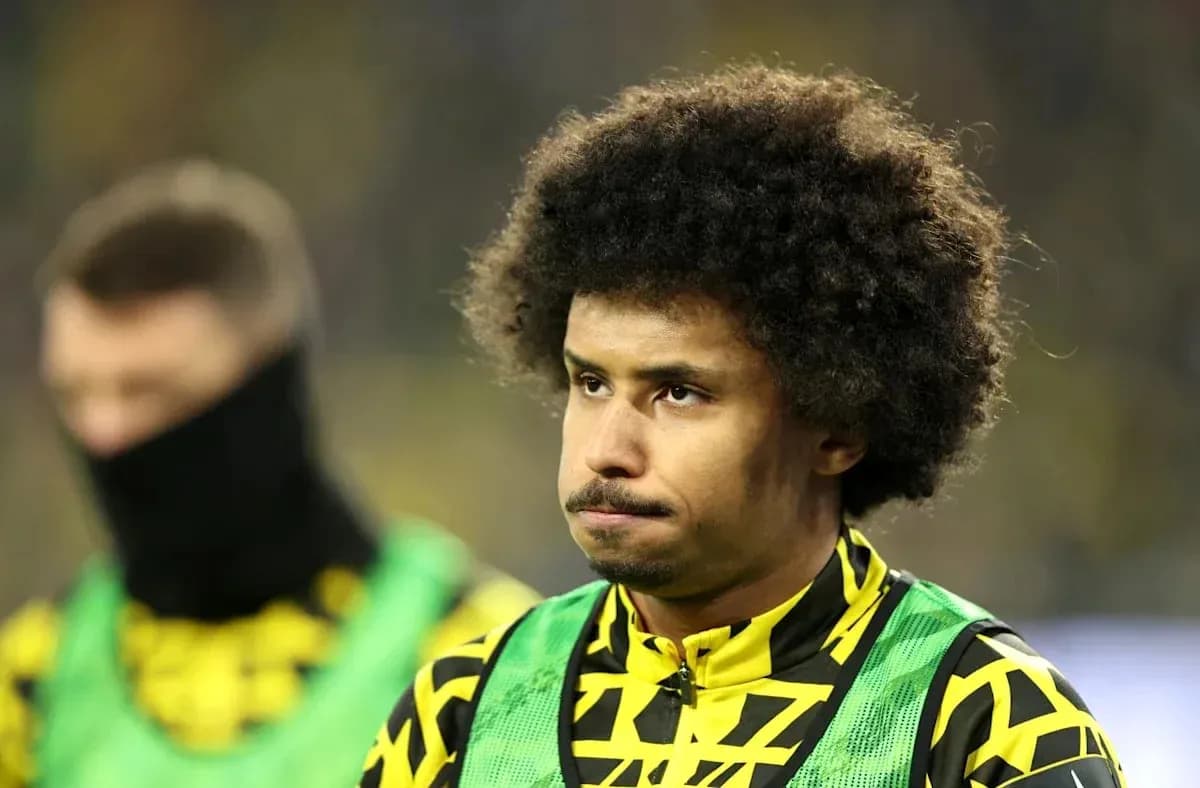 Player in training gear on sidelines during match Player in training gear on sidelines during match