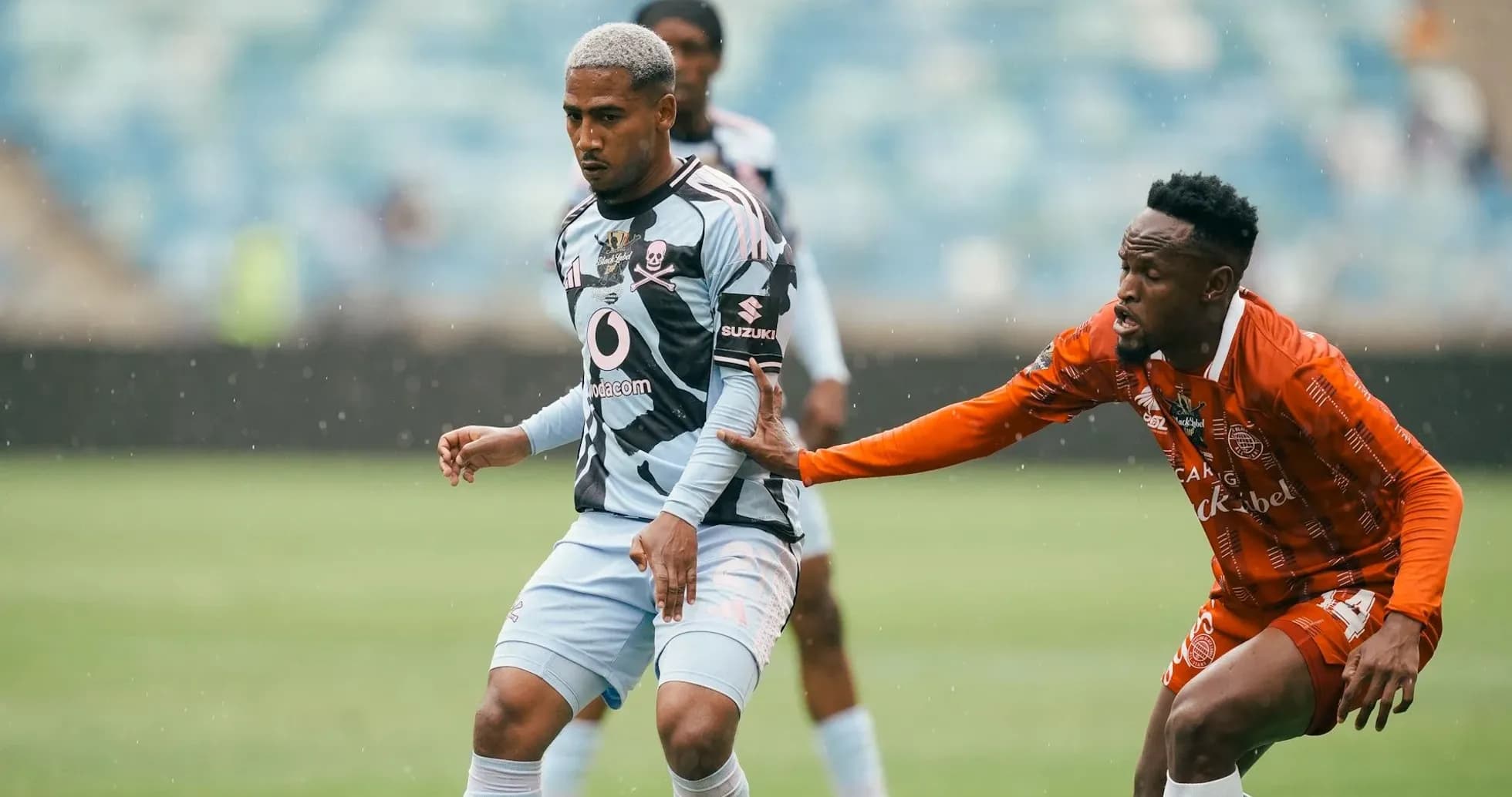 Two players competing for the ball in rain Two players competing for the ball in rain