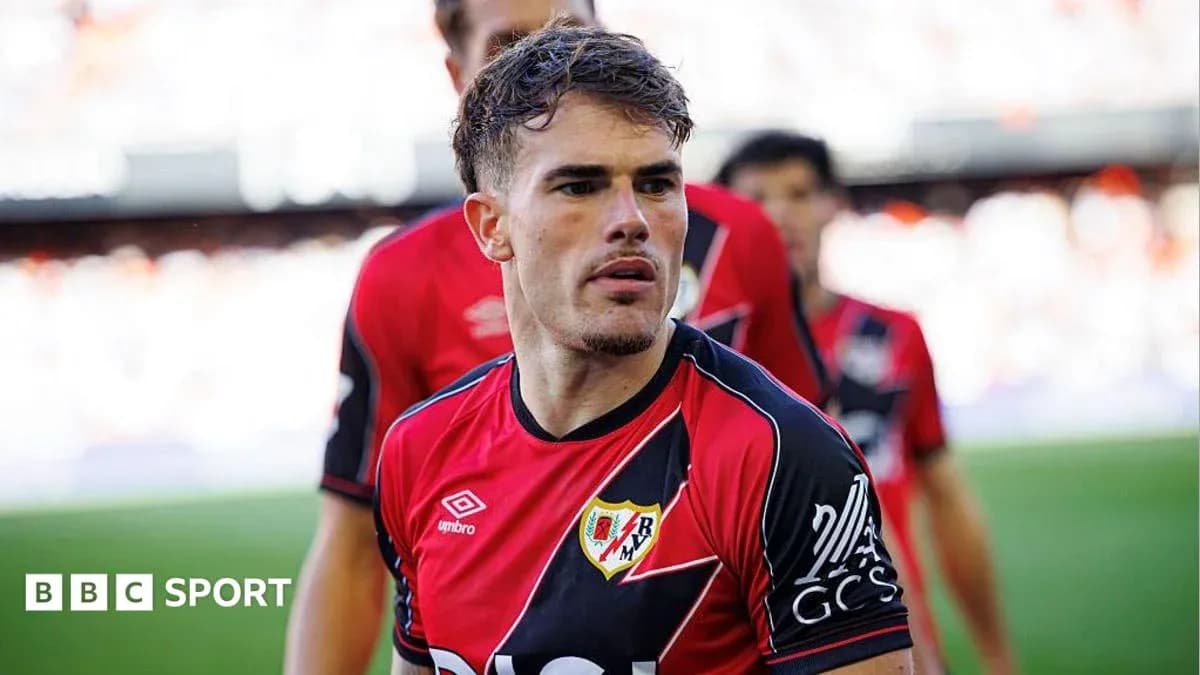 Player in red and black jersey walking onto the field Player in red and black jersey walking onto the field