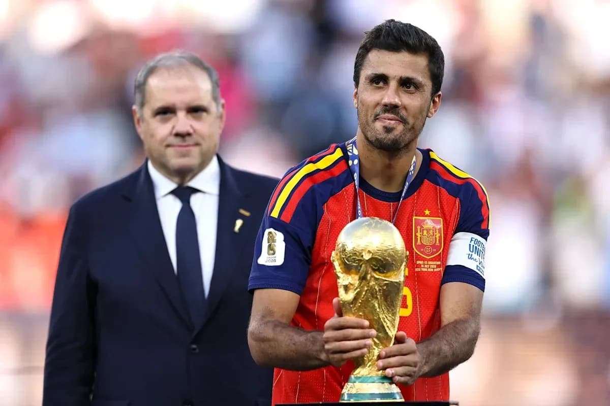 Player holding World Cup trophy with official beside Player holding World Cup trophy with official beside
