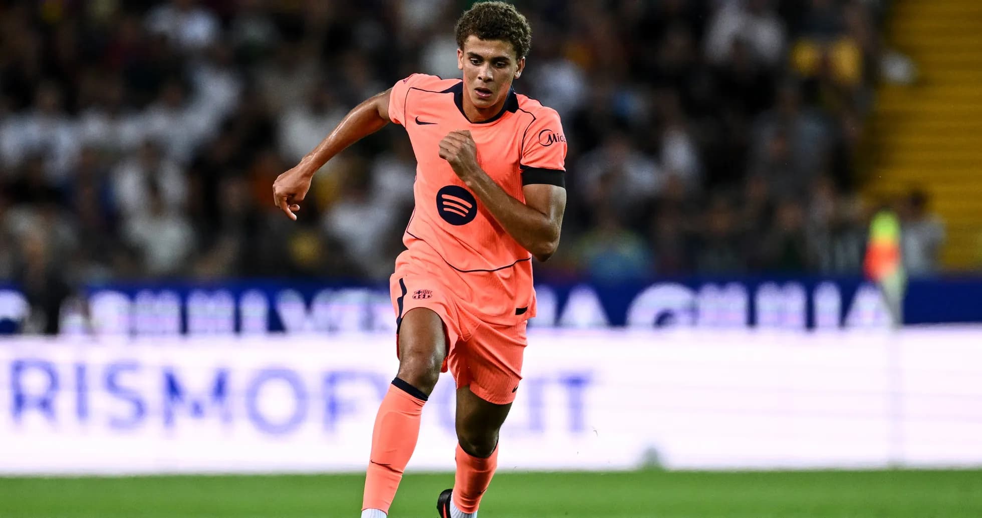 Player running during a football match in bright kit Player running during a football match in bright kit