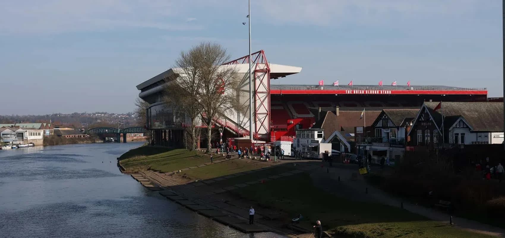 River scene with stadium and people near water River scene with stadium and people near water