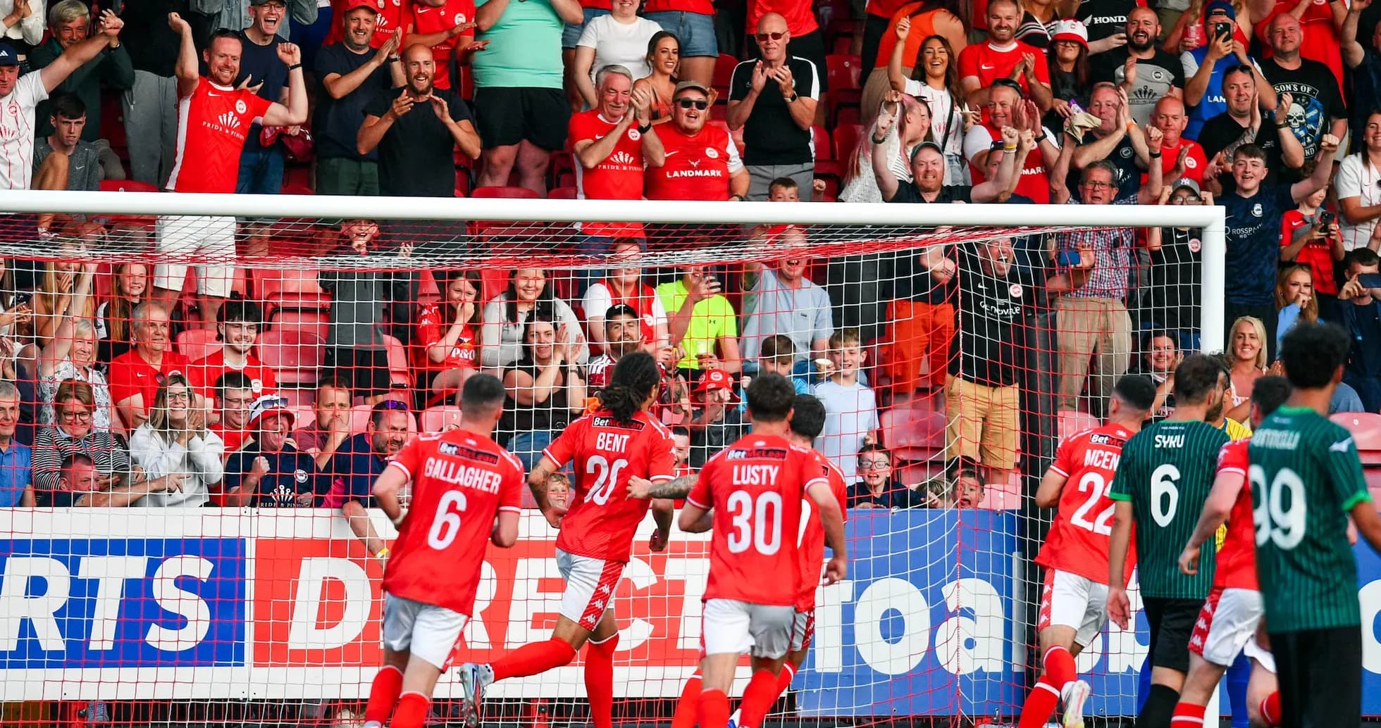 Larne players celebrating a goal with fans Larne players celebrating a goal with fans