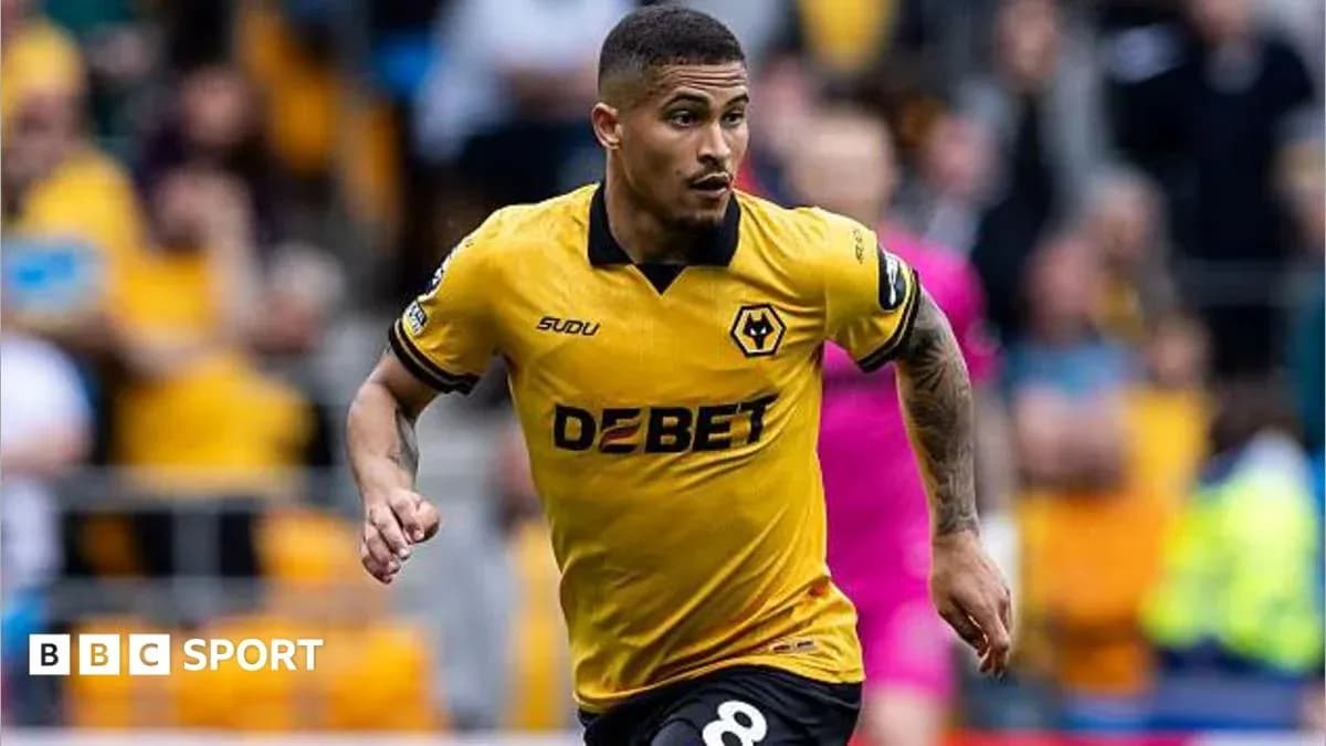 Player in yellow Wolves kit running on field Player in yellow Wolves kit running on field