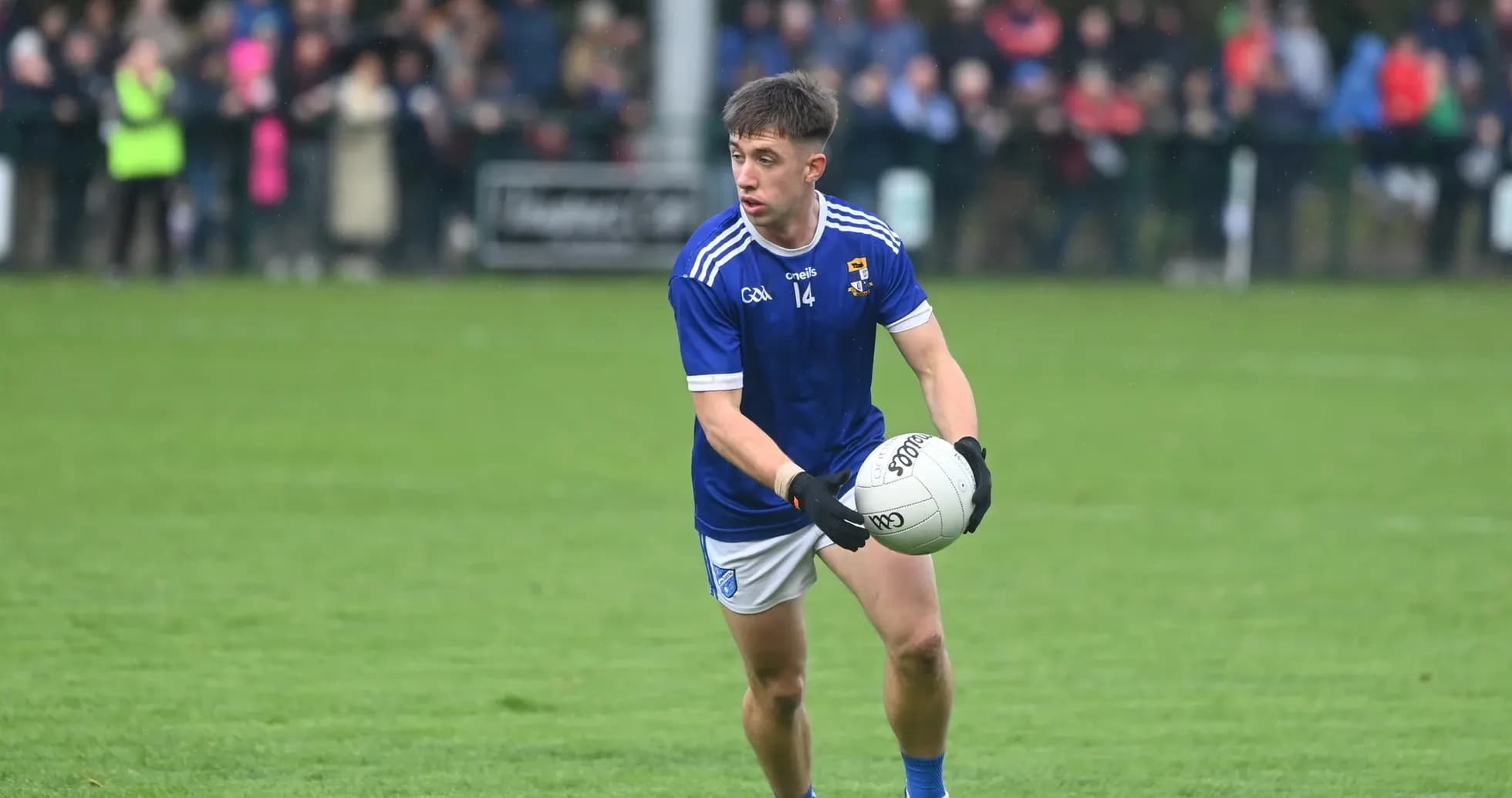 Player in blue jersey holding a Gaelic football Player in blue jersey holding a Gaelic football