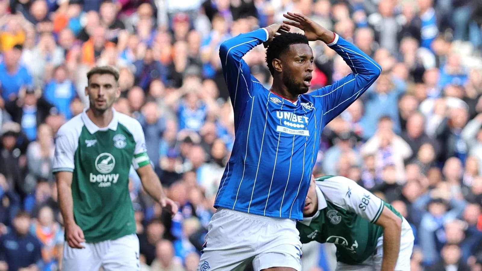 Player in blue celebrating a goal with fans in background Player in blue celebrating a goal with fans in background