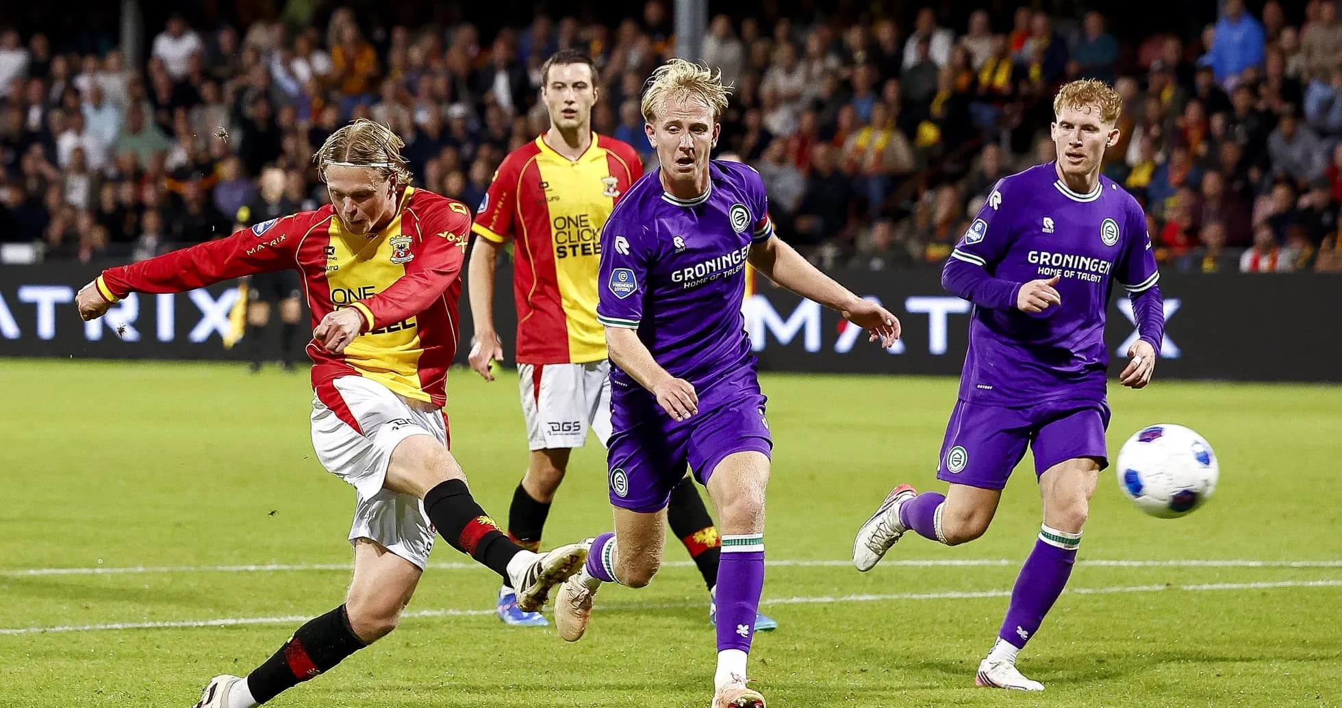 Player striking the ball during a football match Player striking the ball during a football match