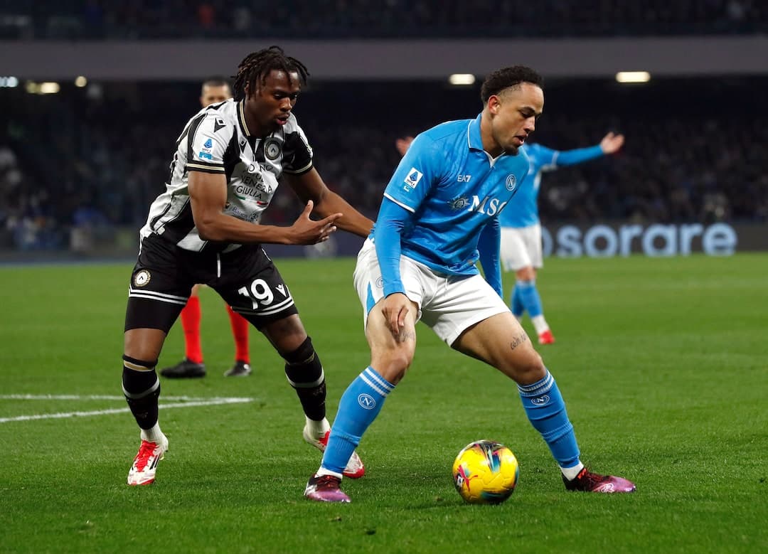 Napoli player dribbling against Udinese opponent Napoli player dribbling against Udinese opponent