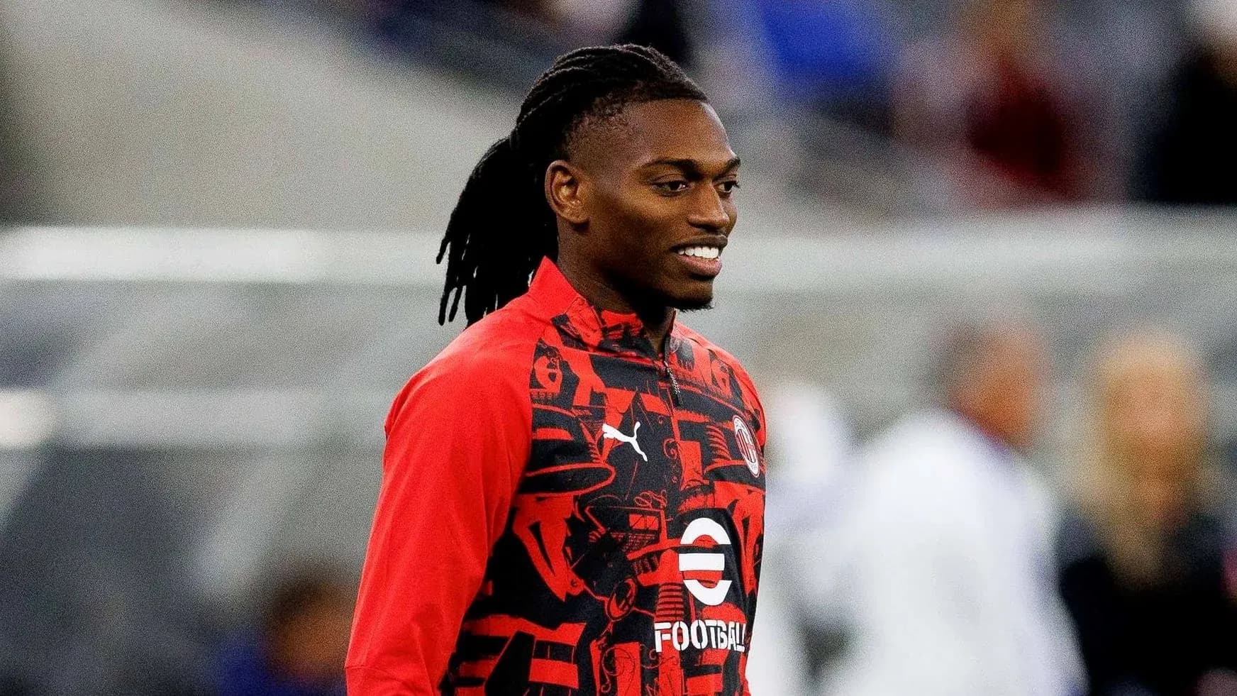 Player wearing red training jacket on the field Player wearing red training jacket on the field