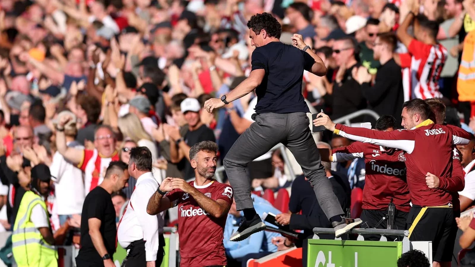 Coach celebrating with fans during a match Coach celebrating with fans during a match