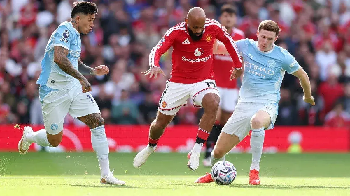 Players from Manchester United and Manchester City contesting the ball Players from Manchester United and Manchester City contesting the ball