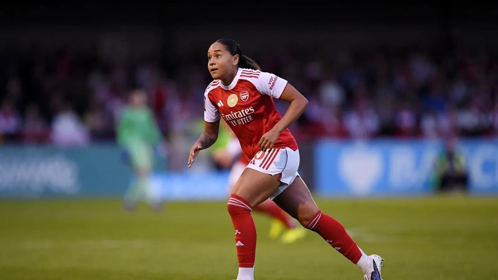 Player in Arsenal kit running on the field Player in Arsenal kit running on the field