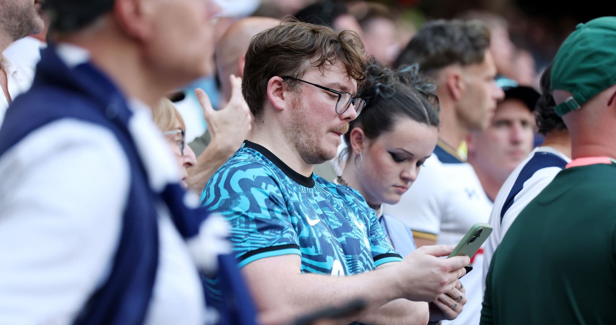 Fans focused on their phones during the event Fans focused on their phones during the event