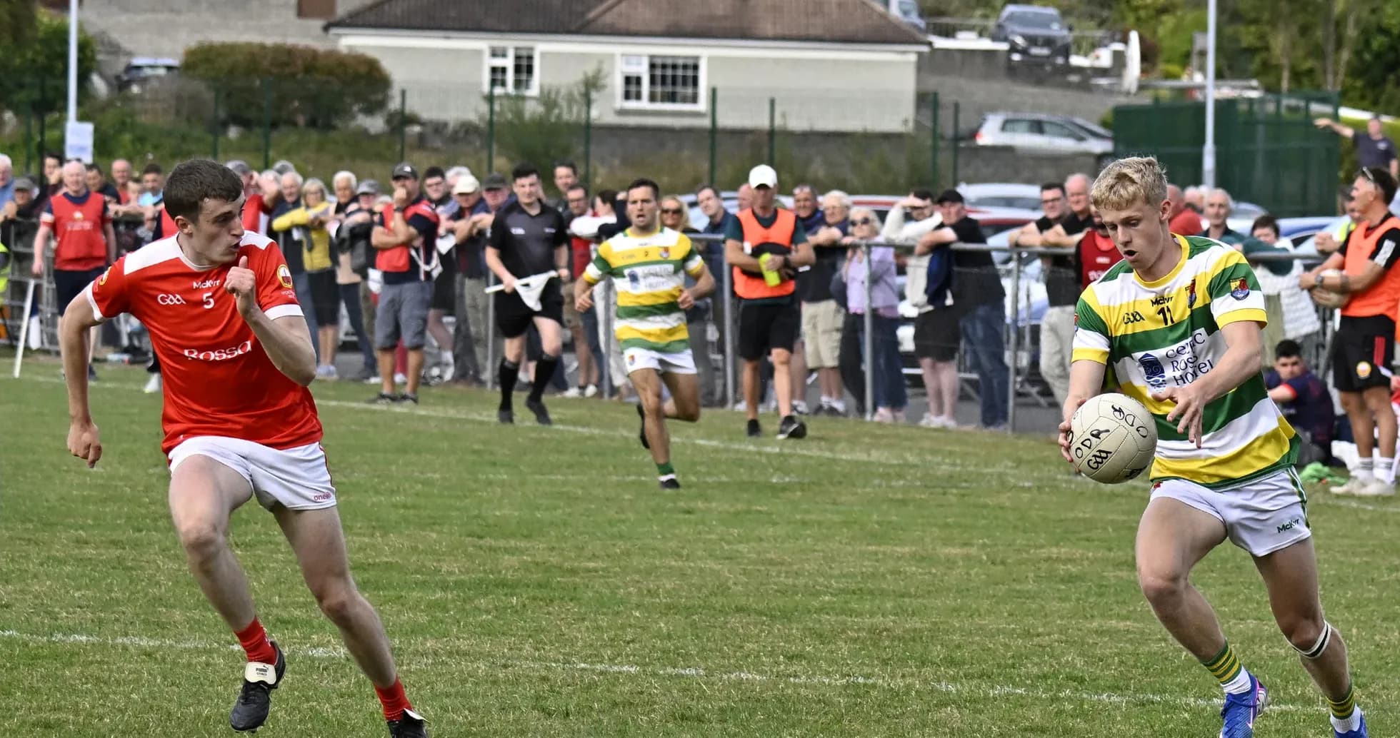 Player in green and yellow shirt receiving ball on field Player in green and yellow shirt receiving ball on field