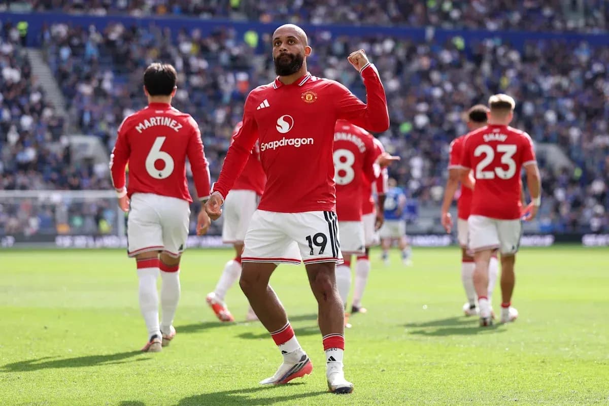 Player celebrating a goal with teammates in stadium Player celebrating a goal with teammates in stadium