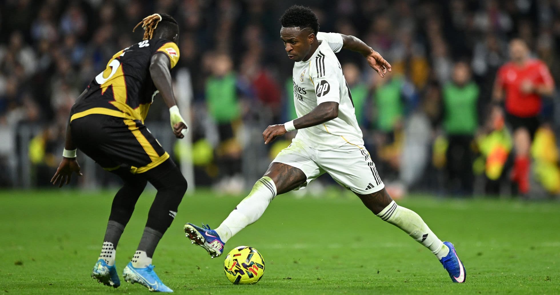 Vinícius Júnior dribbling past opponent during match Vinícius Júnior dribbling past opponent during match