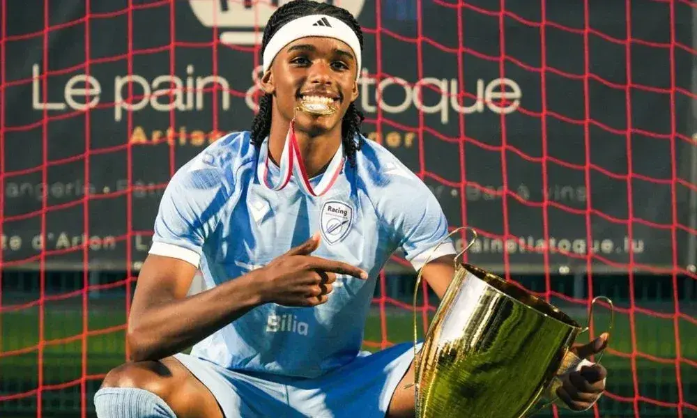 Player celebrating with trophy in front of goal net Player celebrating with trophy in front of goal net