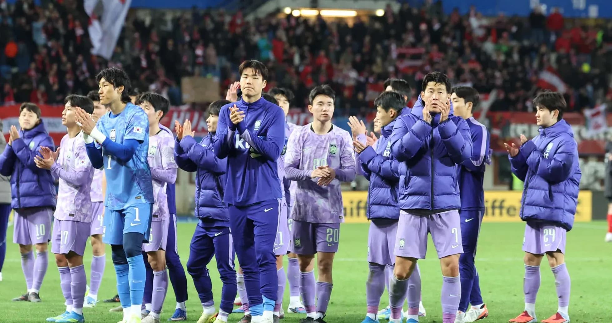 Team in purple jackets applauding fans after match Team in purple jackets applauding fans after match