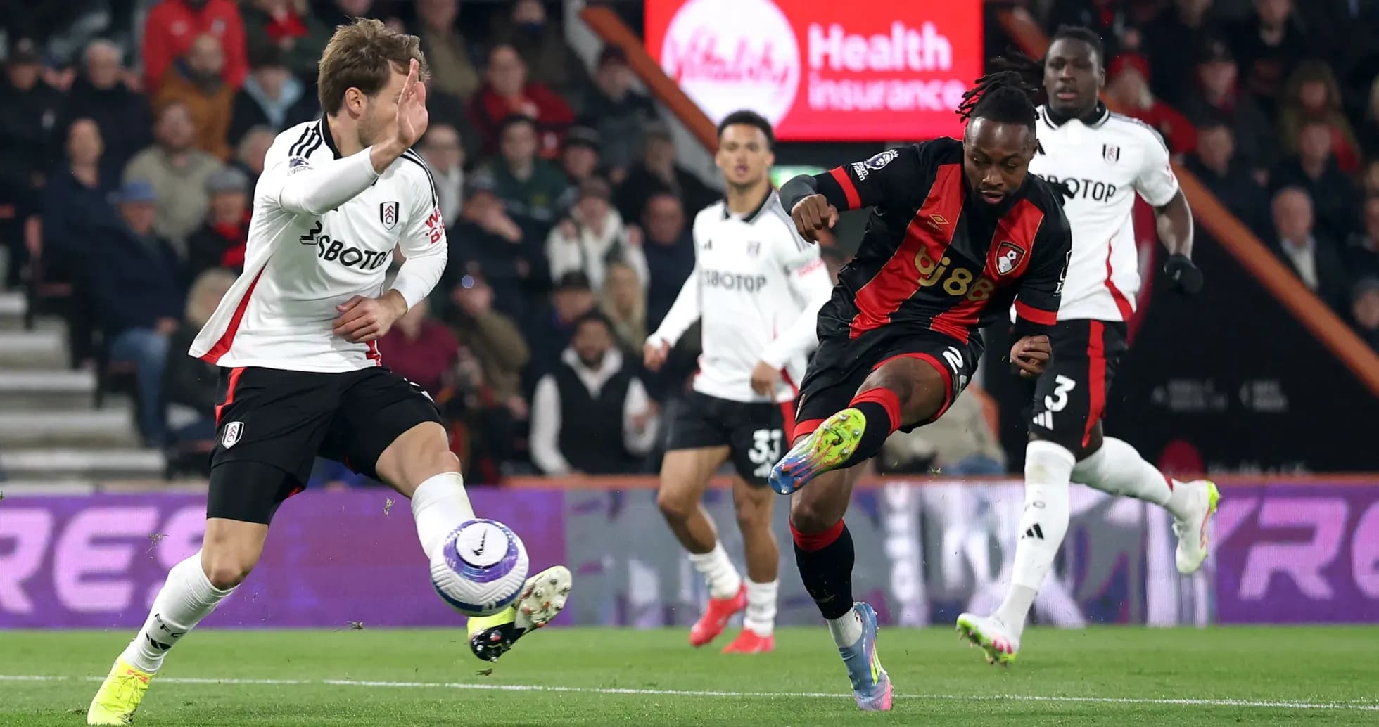 Fulham player challenges Bournemouth opponent for the ball Fulham player challenges Bournemouth opponent for the ball