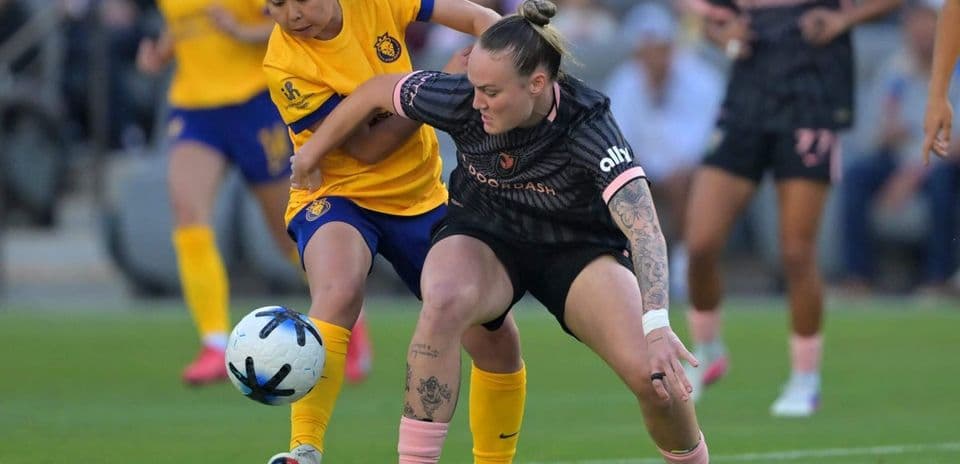 Players competing for the ball in NWSL match Players competing for the ball in NWSL match