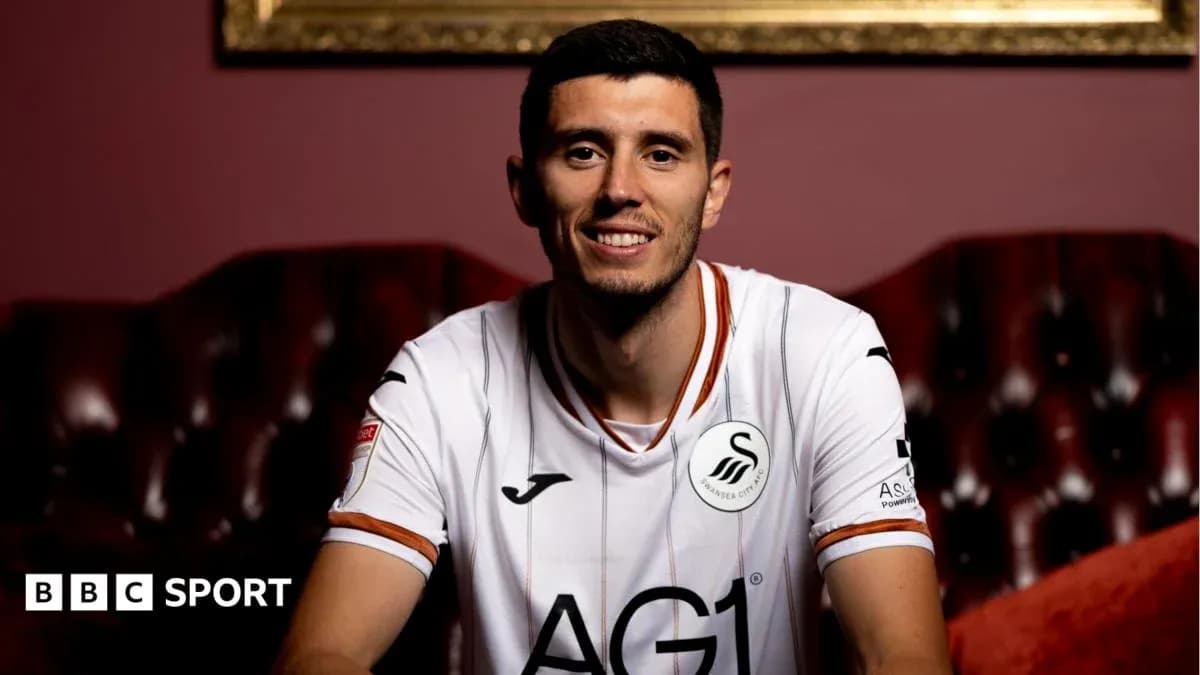Player smiling in Swansea City jersey on couch Player smiling in Swansea City jersey on couch